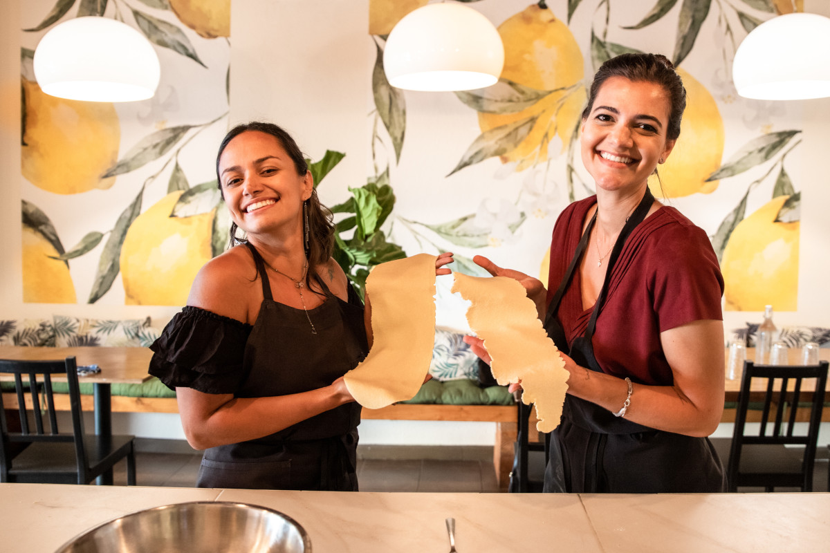 two women holding home-made pasta